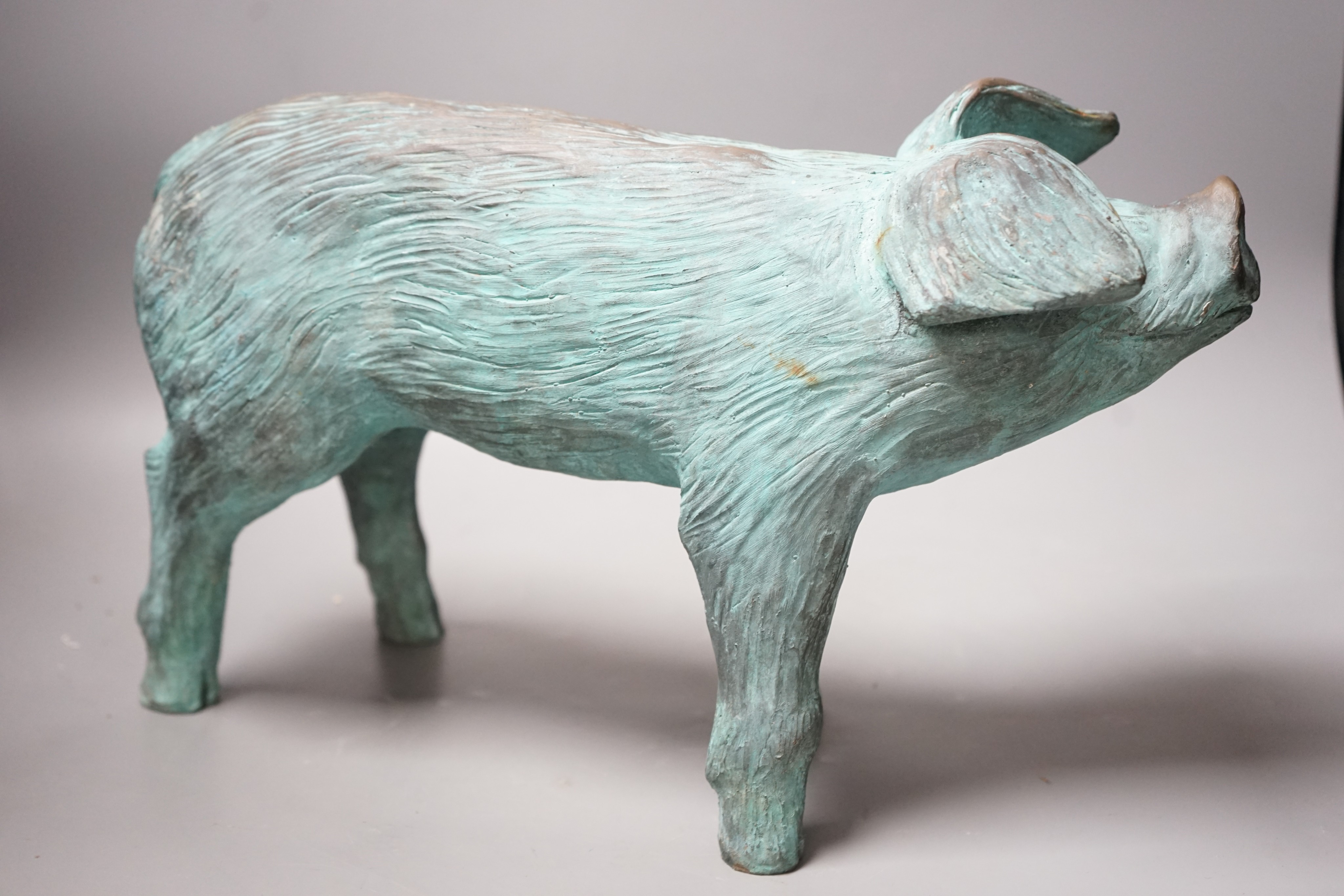 A cold cast resin bronze pig initialled 'JP', 40cm wide